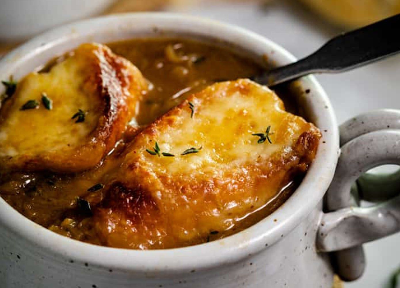 mug of french onion soup with a spoon