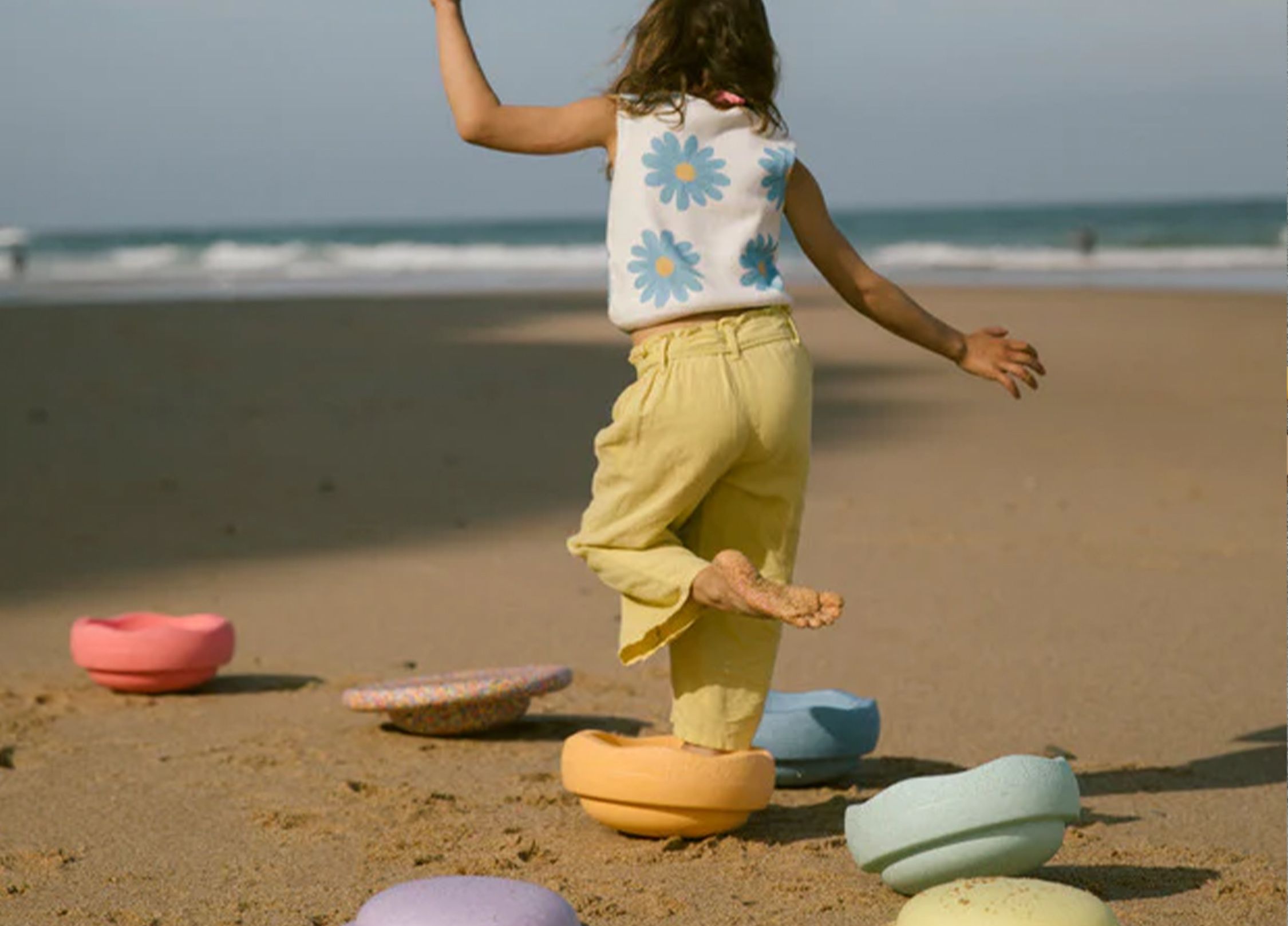 A girl playing with Stapelstein on the beach.