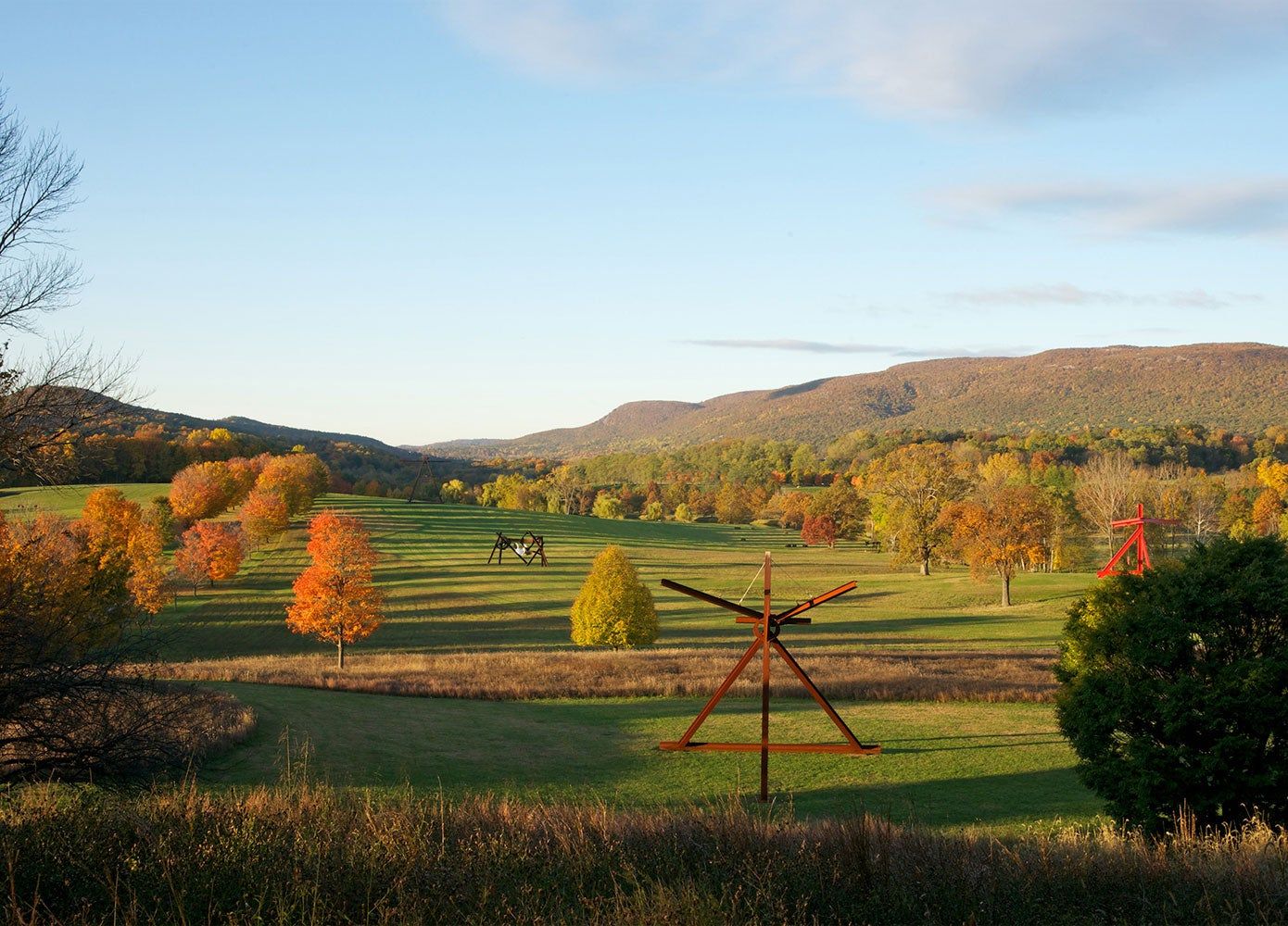 Storm King Art Center in the fall depicted are sculptures created by Mark di Suvero in a large valley.