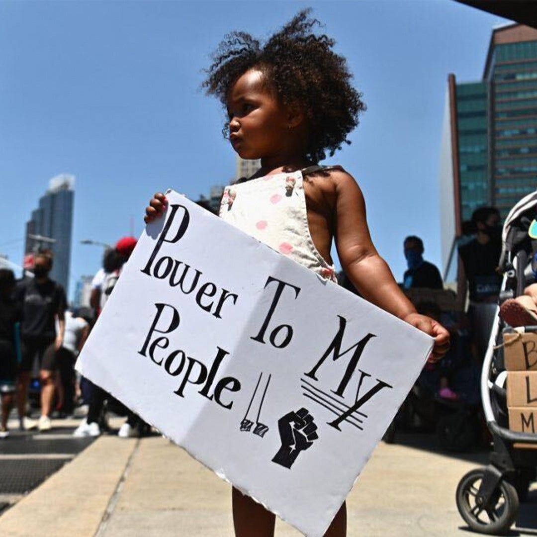 A little Black girl participating in the BLM Children's March on June 9, 2020 holds sign that reads "Power To My People"