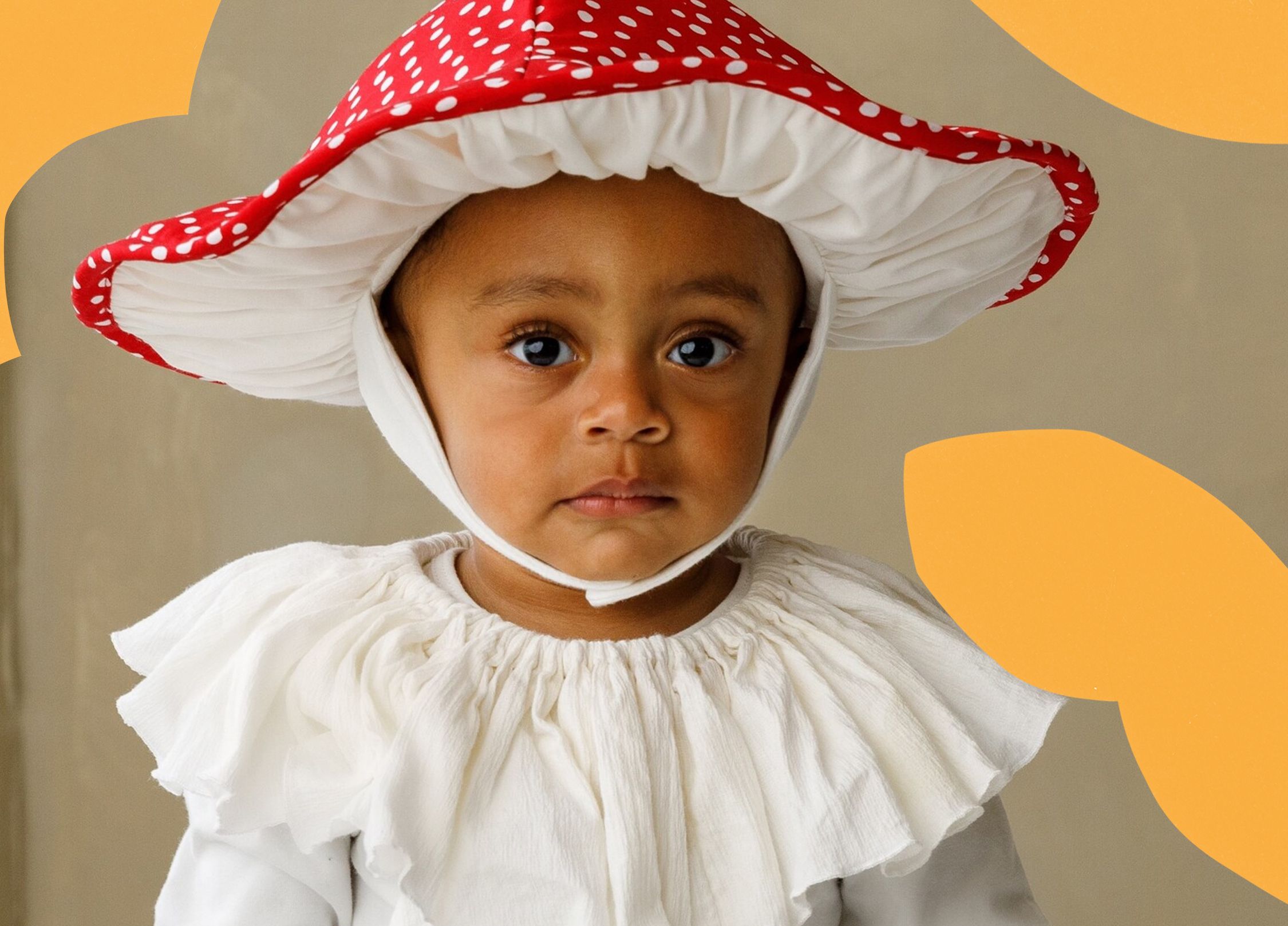 A toddler wearing a mushroom toadstool hat costume.