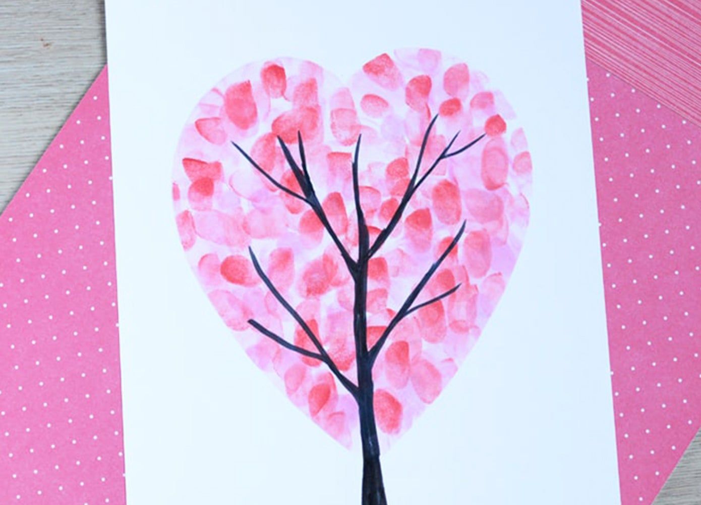 A tree with fingerprints shaped into a heart painted onto a piece of paper
