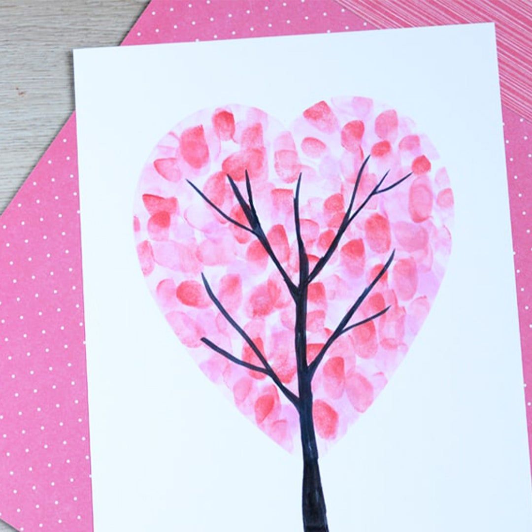 A tree with fingerprints shaped into a heart painted onto a piece of paper