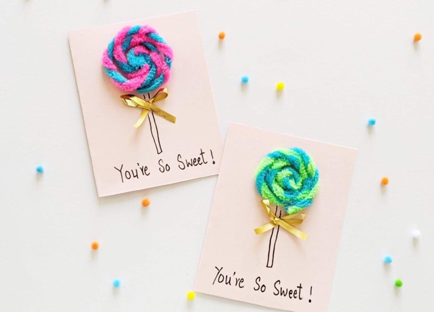 Two cards that read "You're So Sweet!" with pipe cleaner lollipops on top of them