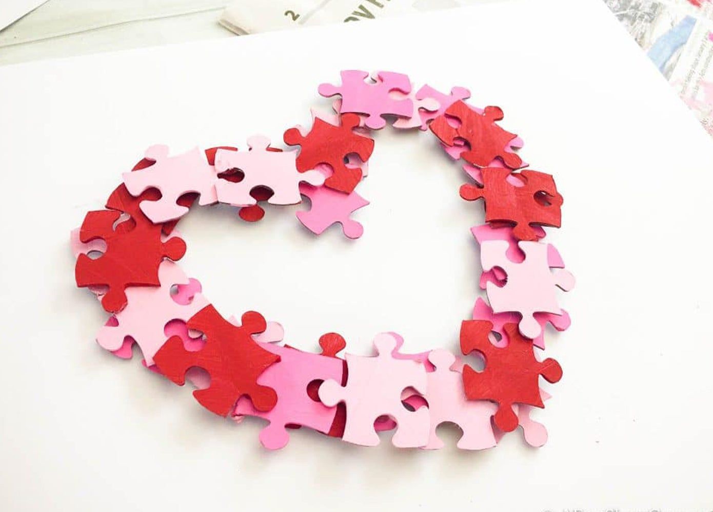 Painted puzzle pieces glued together to create a heart-shaped wreath