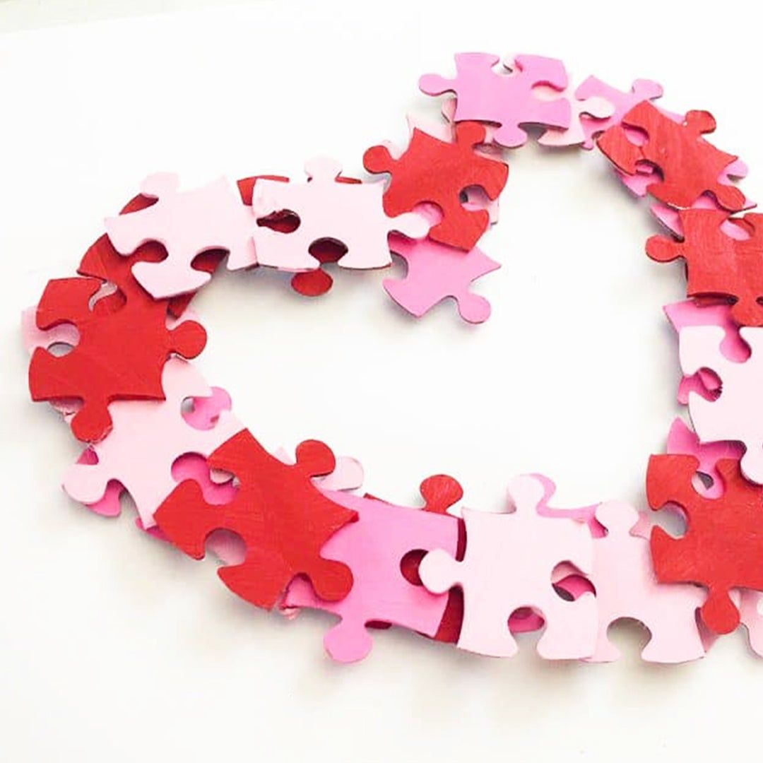 Painted puzzle pieces glued together to create a heart-shaped wreath
